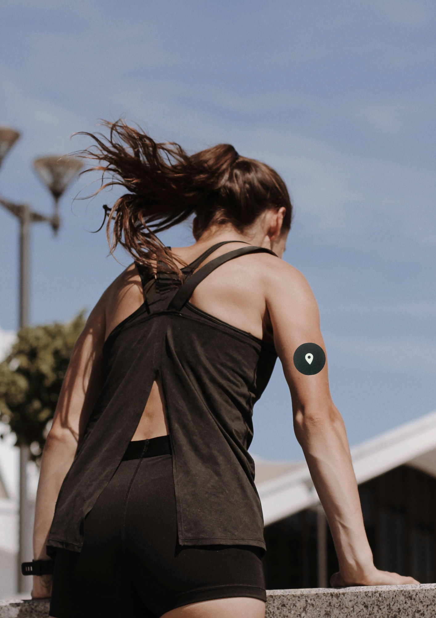 picture of woman jumping wall wearing the wellbeing agent CGM sticker patch