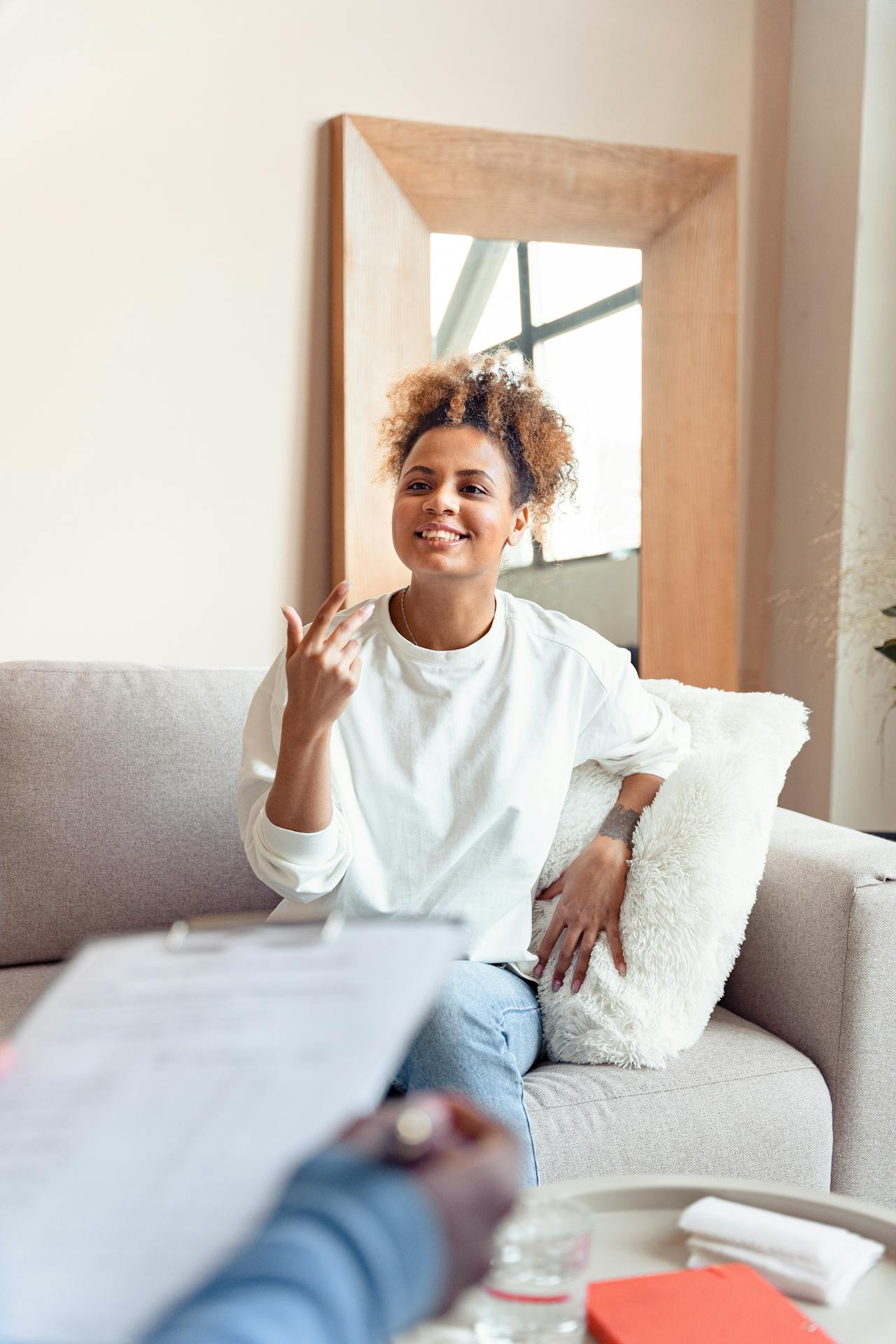picture of woman sitting on couch smiling in therapy